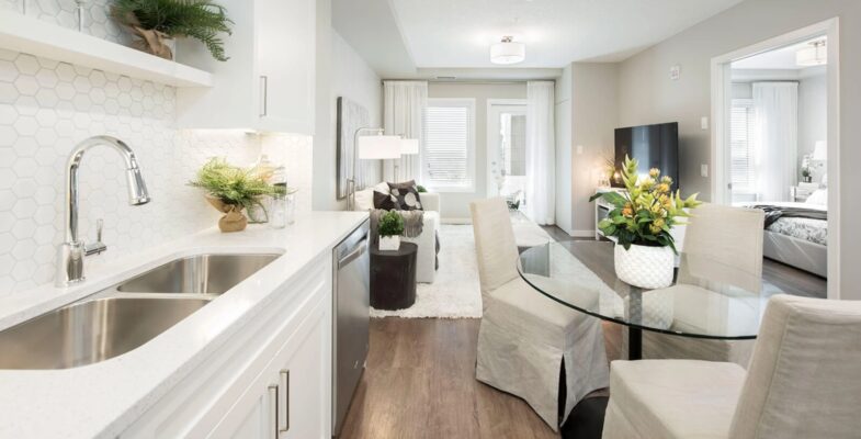 Modern 1 bedroom + den suite featuring a spacious dining space and well-equipped kitchen area.