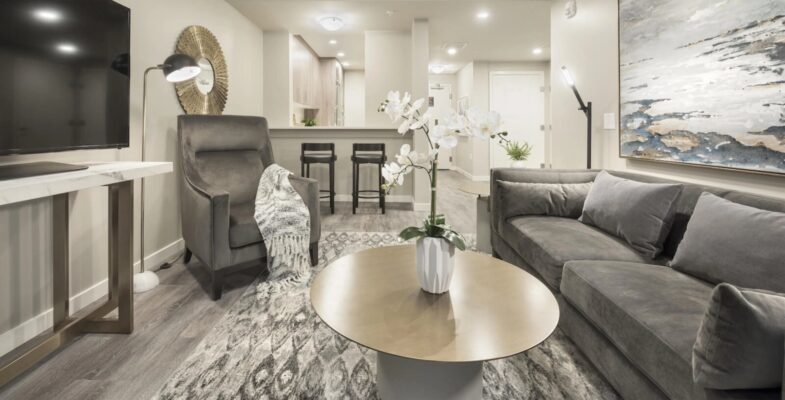 Modernly furnished 1-bedroom suite living room and kitchen in Calgary, showcasing contemporary interiors suitable for seniors seeking assisted living