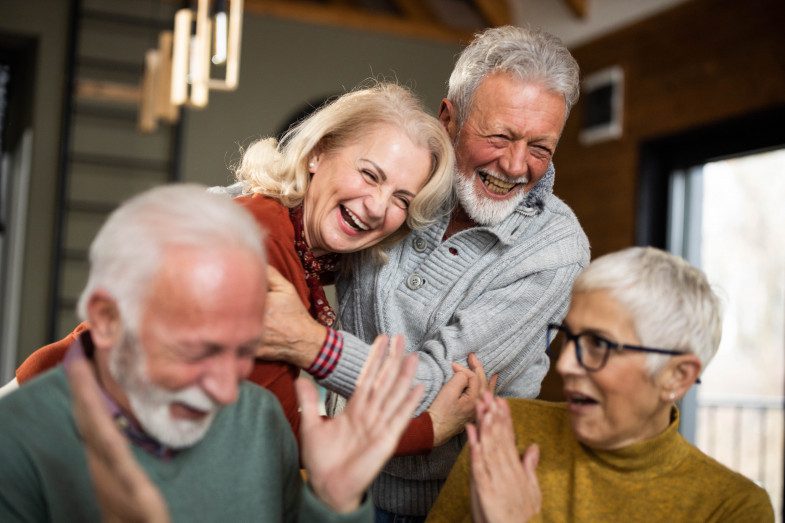 Cheerful mature couples laughing at home.