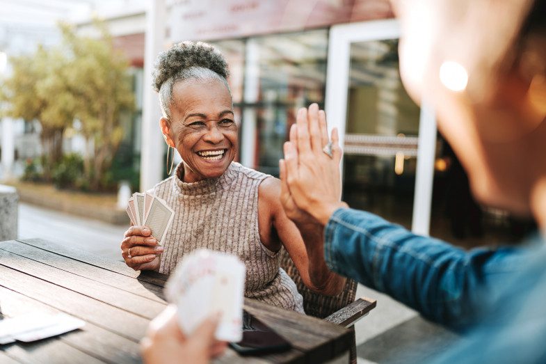 Senior women friends playing cards